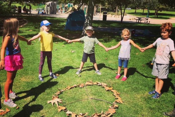 A group of children holding hands outside at Nature Scouts Collective.