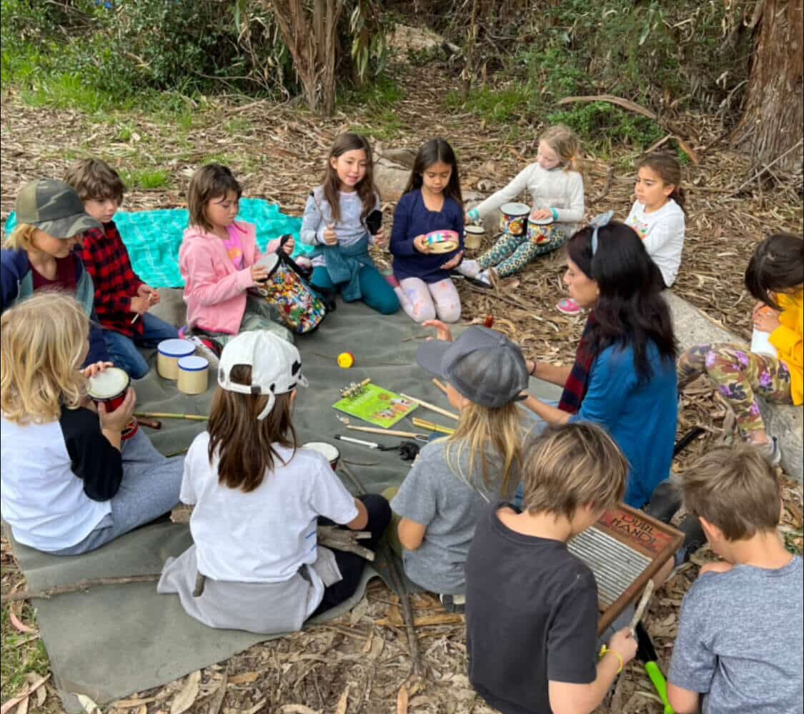 Children sitting in a nature circle playing instruments during a Nature Scouts Collective summer camp in North County San Diego