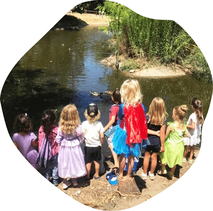 Children observing ducks by a pond during a Nature Scouts Collective outdoor nature camp in North County San Diego.