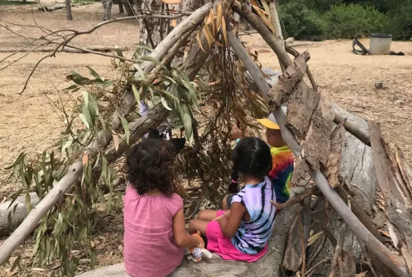 nature-based-learning-children-building-shelter-blog Children build a branch shelter during nature-based learning in North County San Diego.